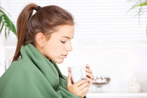 Mujer bebiendo té en casa cubierto con manta —  Fotos de Stock