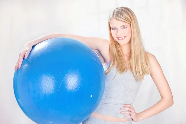 Mulher segurando bola pilates azul — Fotografia de Stock