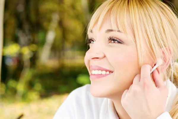 Vrouw in het park met koptelefoon — Stockfoto