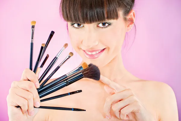 Mulher segurando conjunto de maquiagem escovas — Fotografia de Stock