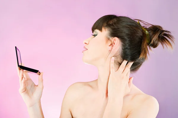 Woman checking face skin in mirror — Stok fotoğraf