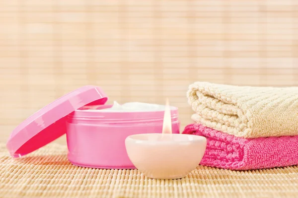 Krem, ręczniki i świeca — Zdjęcie stockowe