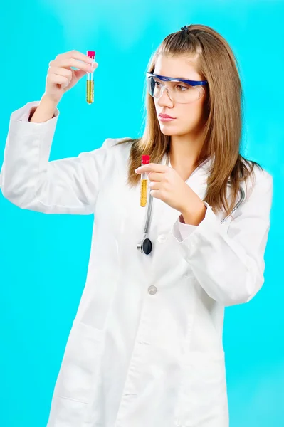 Doctora mirando los tubos químicos — Foto de Stock