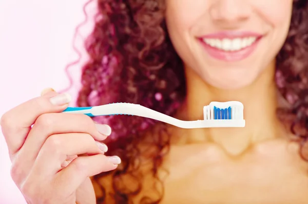 Teeth brush and girl's smile behind — Stock Photo, Image