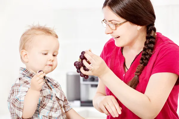 Mère nourrissant l'enfant avec du raisin — Photo