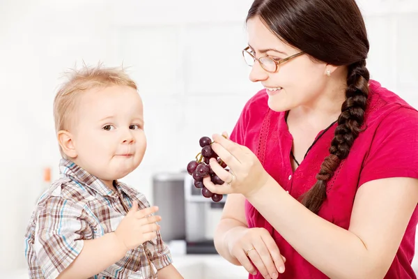Moeder voeding kind met druivenmost — Stockfoto