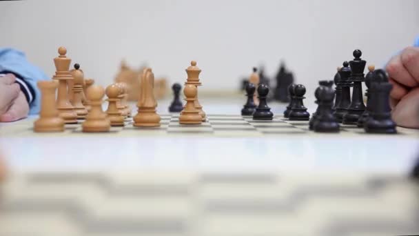Hände von zwei Schachspielern und schwarze Dame nehmen weiße Dame — Stockvideo