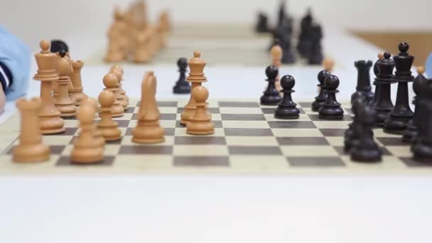 Руки двух шахматистов и черной королевы берут белую королеву — стоковое видео