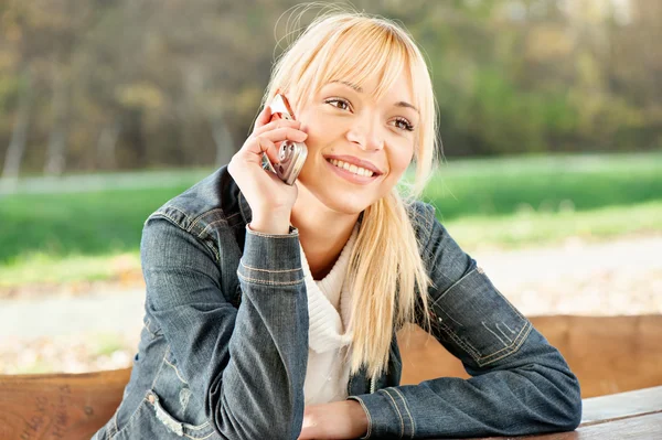 Mujer en el parque tomando una llamada telefónica — Foto de Stock