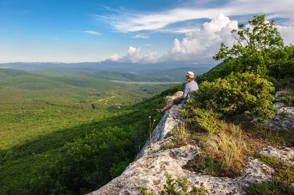 Wandermann im Sonnenuntergang am Rand sitzend — Stockfoto