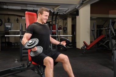 spor olarak dumbbell pazı çalışma yapan genç erkek