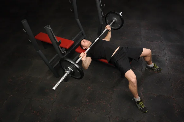 Młody człowiek robi Bench Press Workout w siłowni — Zdjęcie stockowe