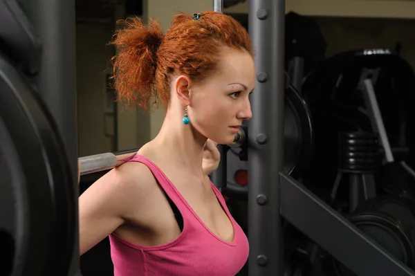 Young girl doing squats with barbell — Stock Photo, Image