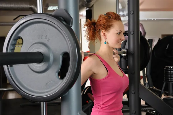 Young girl doing squats with barbell — Stock Photo, Image