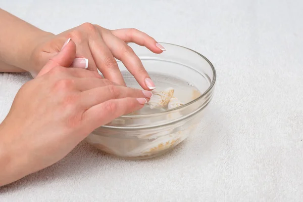 Mani in acqua con conchiglie — Foto Stock