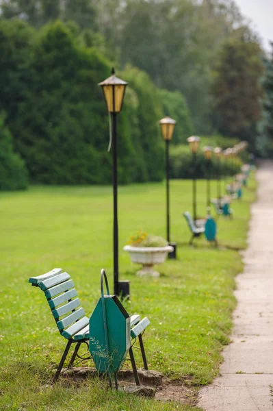 Park bench in row, selective focus on first — Stock Photo, Image