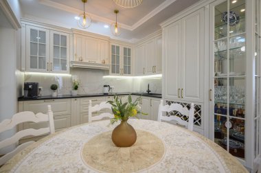 Modern klasik beyaz lüks mutfak ve stüdyo dairesinin içindeki yemek odası.