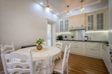 Modern klasik beyaz lüks mutfak ve stüdyo dairesinin içindeki yemek odası.