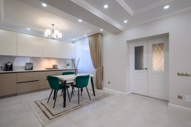 Modern klasik beyaz ve bej renkli lüks mutfak stüdyo dairesinin içinde yemek odası var.