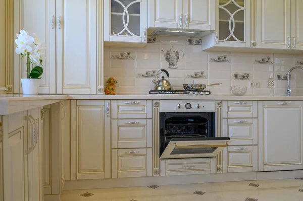 传统的白色和米黄色厨房家具 工作室公寓的烤箱开着 — 图库照片