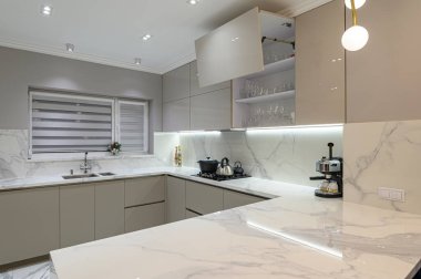 Lüks, büyük, modern, beyaz mermer mutfak ve yemek odası birleşimi.