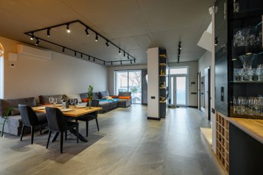 Modern lüks stüdyo daire. Geniş oturma odasında yemek masası var.