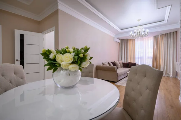 Luxury white and pink modern studio apartment interior with dining table, living area and bedroom