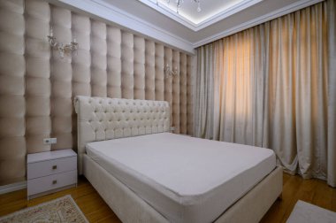 Konforlu ve iyi tasarlanmış, bej renklerde, zarif ve modern detaylarla büyük bir yatak odası.