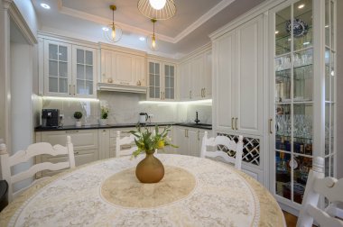 Modern klasik beyaz lüks mutfak ve stüdyo dairesinin içindeki yemek odası.