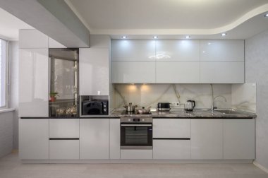 Interior of well designed modern trendy white kitchen, front view