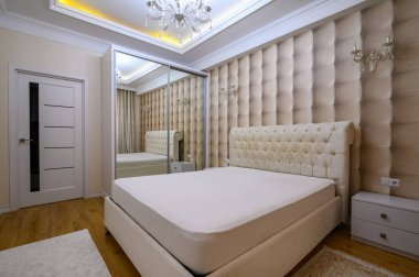 Konforlu ve iyi tasarlanmış, bej renklerde, zarif ve modern detaylarla büyük bir yatak odası.