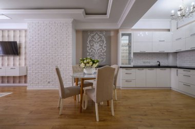 Pembe ve beyaz duvarları olan lüks beyaz modern mutfak ve stüdyo dairede ahşap döşeme.