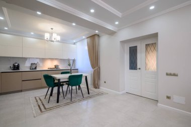 Modern klasik beyaz ve bej renkli lüks mutfak stüdyo dairesinin içinde yemek odası var.