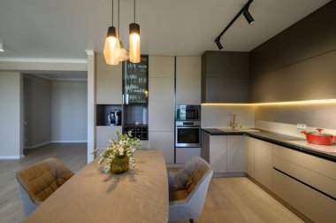 Büyük, modern, gri, lüks mutfak ve stüdyo dairenin içindeki yemek odası.