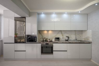 Interior of well designed modern trendy white kitchen, front view