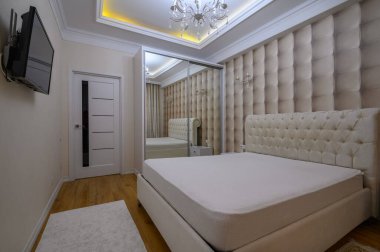 Konforlu ve iyi tasarlanmış, bej renklerde, zarif ve modern detaylarla büyük bir yatak odası.