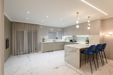 Lüks, büyük, modern, beyaz mermer mutfak ve yemek odası birleşimi.
