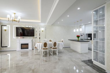 Luxury large domestic kitchen with marble floor, island and dining table