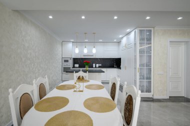 Luxurious large modern domestic kitchen with marble floor and serverd dining table
