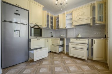 Showcase interior of modern cream colored kitchen, drawers retracted