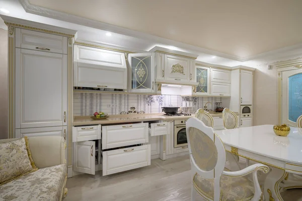 Interior renovation showcase of rich classic white kitchen, drawers retracted