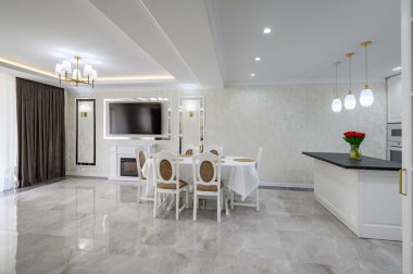 Luxury large modern white large domestic kitchen with glossy marble floor, kitchen island and dining table