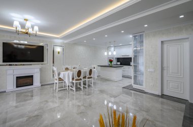 Luxury large modern white large domestic kitchen with glossy marble floor, kitchen island and dining table