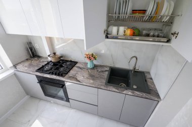 High angle view to white compact modern domestic kitchen furniture after renovation