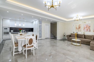 Luxurious large domestic kitchen with marble floor, dining table and sofa