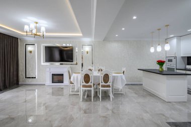 Luxury large modern white large domestic kitchen with glossy marble floor, kitchen island and dining table