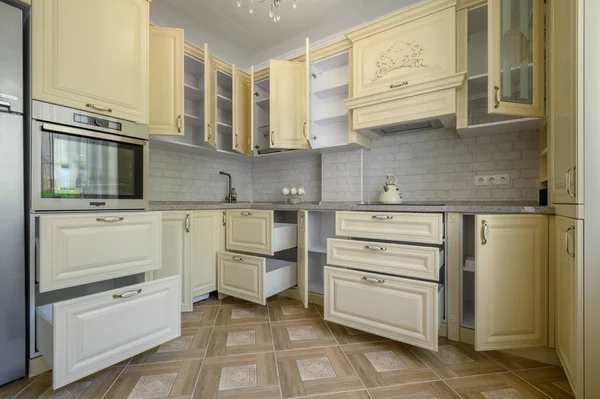 Showcase interior of modern cream colored kitchen, drawers retracted