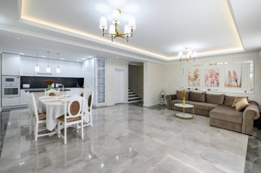 Luxurious large domestic kitchen with marble floor, dining table and sofa