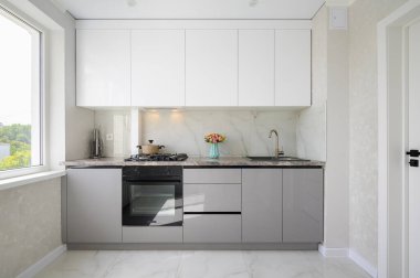 Interior of white and grey small modern domestic kitchen furniture