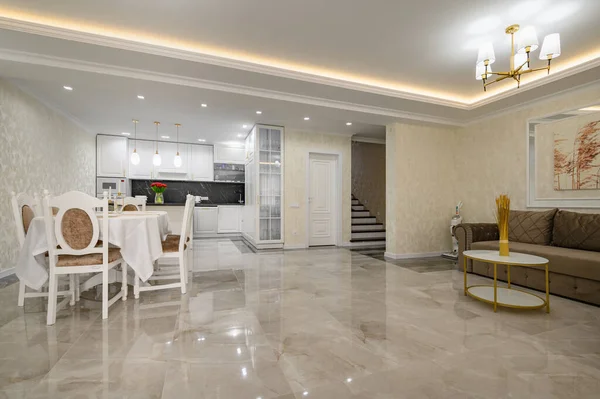 Huge luxurious home studio kitchen with marble floor, dining table and sofa